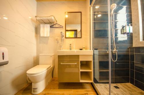 a bathroom with a toilet and a sink and a shower at Summer Bay Inn in Hengchun South Gate