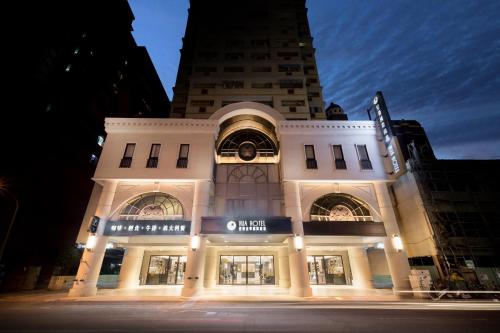 a large white building with a clock on it at Hua Hotel in Tainan