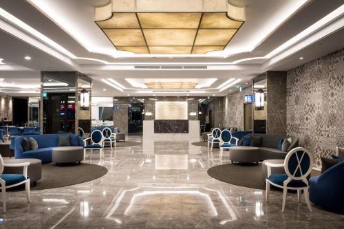 a lobby with couches and chairs in a building at Hua Hotel in Tainan