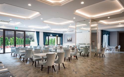 a dining room with tables and chairs and windows at 台南星鑽國際商旅 Hua Hotel in Tainan
