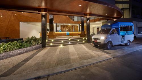 a blue and white truck parked in front of a building at Whale Hua Hin - SHA Plus in Hua Hin