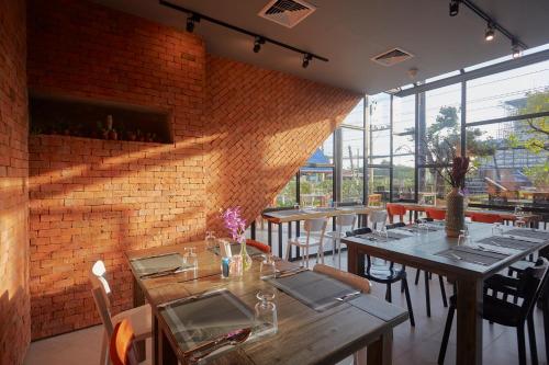 a restaurant with tables and chairs and a brick wall at Whale Hua Hin - SHA Plus in Hua Hin