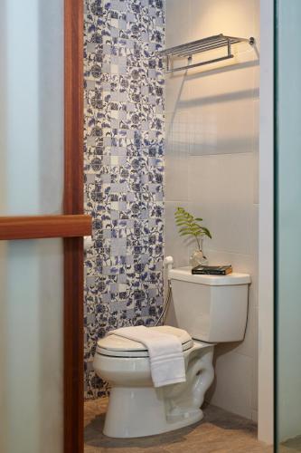 a bathroom with a white toilet and a shower at Whale Hua Hin - SHA Plus in Hua Hin