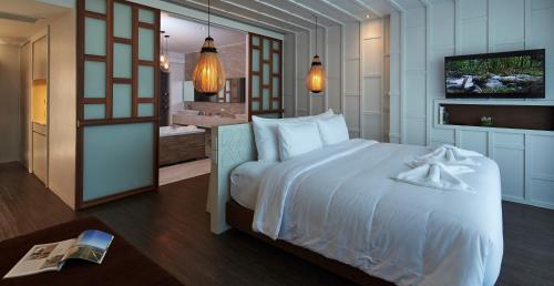a bedroom with a large white bed and a bathroom at Whale Hua Hin - SHA Plus in Hua Hin