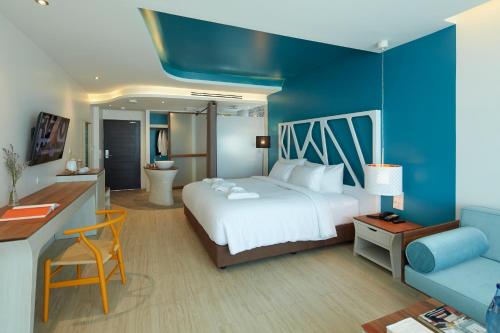 a bedroom with a large bed and a blue wall at Whale Hua Hin - SHA Plus in Hua Hin