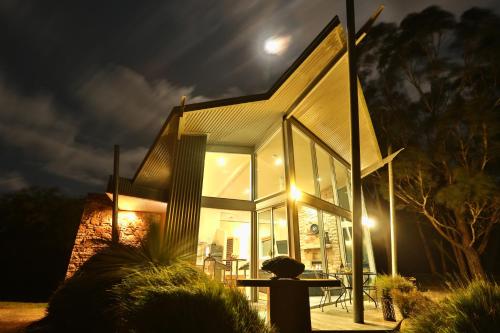 a person standing in front of a house at night at Bushland in Halls Gap