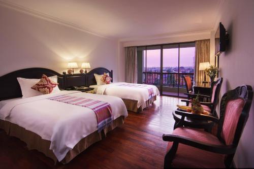 um quarto de hotel com duas camas e uma varanda em Smiling Hotel em Siem Reap