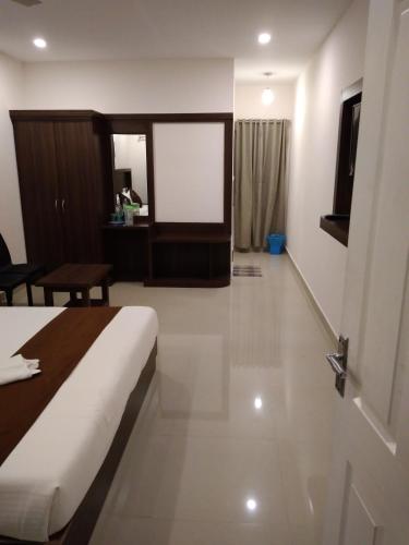 a hotel room with a bed and a screen at Highrange Plaza in Thekkady