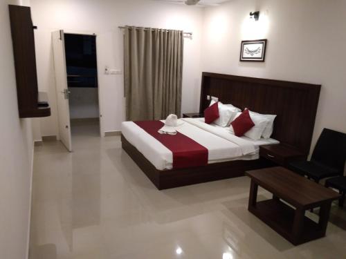 a hotel room with a bed and a chair at Highrange Plaza in Thekkady