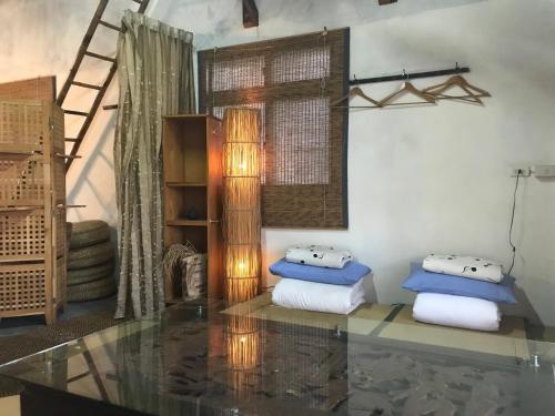 een kamer met 2 kussens en een glazen tafel bij Soothing Stay Backpackers Inn in Tianwei