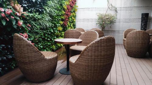 a row of wicker chairs and a table on a patio at Wharney Hotel in Hong Kong