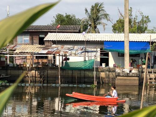 a boy in a red boat in the water at Golden Foyer Suvarnabhumi Airport Hotel in Lat Krabang