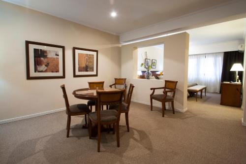 a dining room table and chairs in a room at Tucuman Center Suites&Business in San Miguel de Tucumán