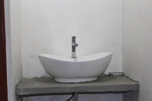 a white sink sitting on a table in a room at Natures Bliss Holidays in Ja-Ela