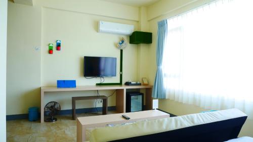 a living room with a couch and a desk with a television at Finest Hour in Chishang