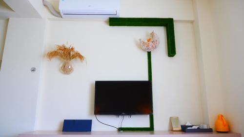 a room with a tv and a cross on the wall at Finest Hour in Chishang