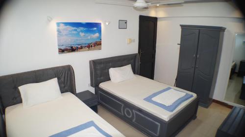 een kamer met twee bedden en een kast erin bij Econo Lodge in Dar es Salaam