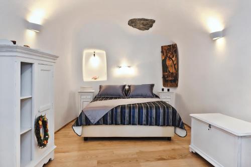 a bedroom with a bed in a white room at Anemomilos in Oia