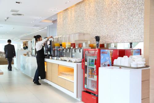 a man is preparing food in a restaurant kitchen at Golden Tulip Zhong Xin Hotel Taichung in Taichung