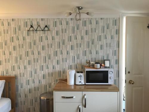 a kitchen with a microwave on a counter in a room at Addison B&B in Guildford