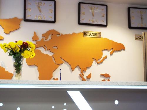 a map of australia on a wall with clocks at Asia Hotel in Târgu Jiu