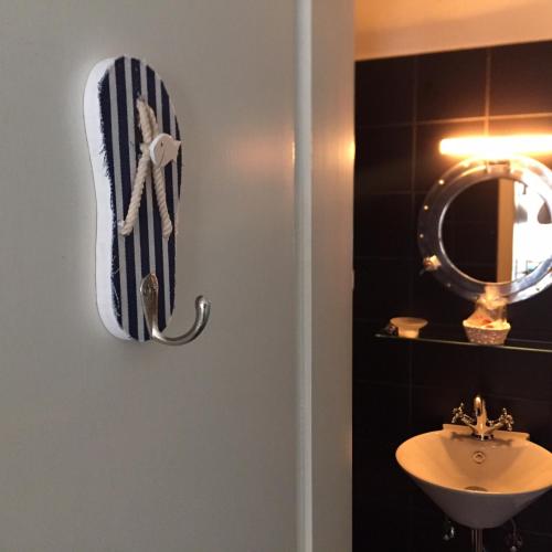 a towel hanging on a wall next to a sink at City Hostel by beans parc in Wilhelmshaven