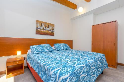 Schlafzimmer mit einem Bett mit blauer Decke und einem Schrank in der Unterkunft Hotel Adria in Mestre