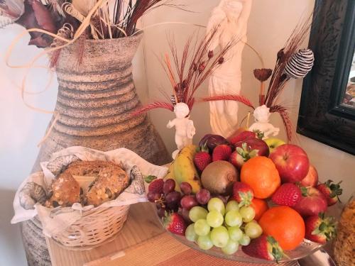 a table with a bowl of fruit and a basket of bread at After8 B&B in Kleinbaai