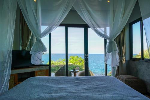 a bedroom with a bed and a view of the ocean at Sai Daeng Resort in Koh Tao