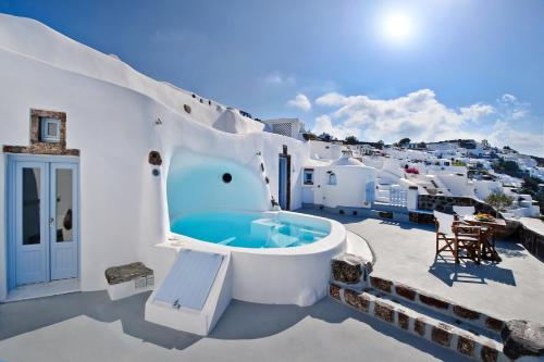 a soaking tub on the roof of a house at Anemomilos in Oia