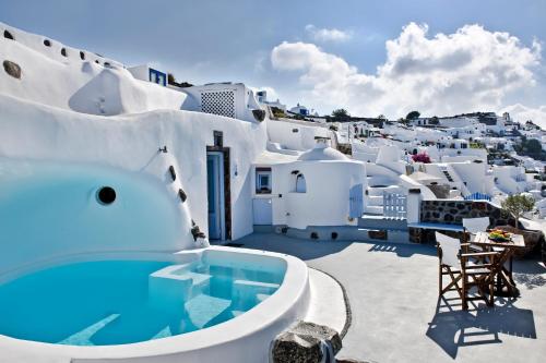a view of a white house with a swimming pool at Anemomilos in Oia