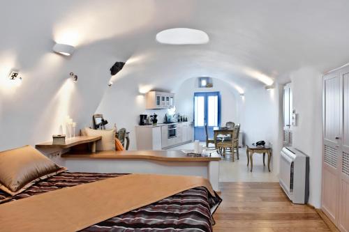 a bedroom with a bed and a kitchen and a room at Anemomilos in Oia
