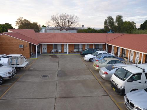 un edificio con coches estacionados en un estacionamiento en Winchester Motel, en Moree