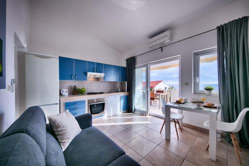 a living room with a blue couch and a table at Seafront Suites Maja in Vis