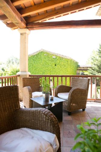 a patio with wicker chairs and a table on a deck at Mas Albereda in Sant Juliá de Vilatorta