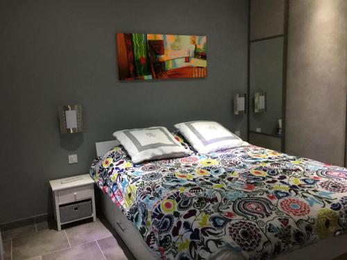 a bedroom with a bed with a colorful comforter at La maison des canards in Romorantin