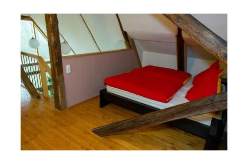 a room with a red bed in a attic at Grünsteinhof - Wohnung Rotstein in Habrachćicy