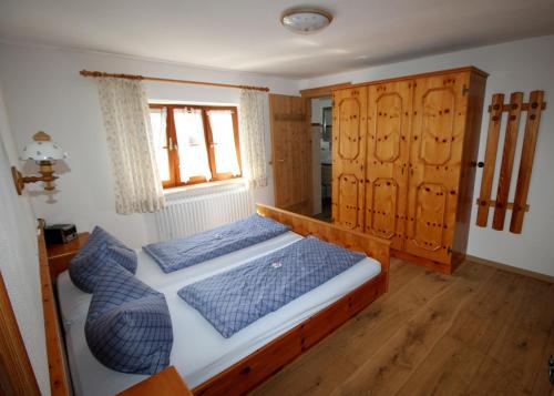 ルーポルディングにあるFerienwohnung Schifterhofのベッドルーム1室(青い枕のベッド1台、窓付)