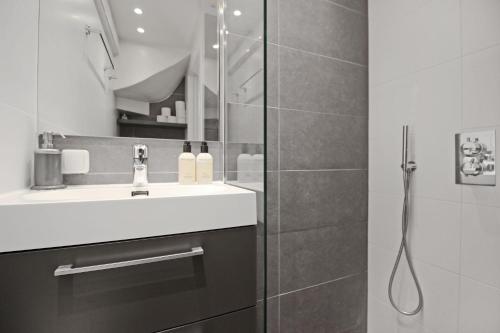 La salle de bains est pourvue d'un lavabo et d'une douche. dans l'établissement Guesthouse Prinsencanal 1, à Amsterdam