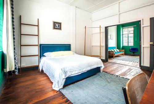 a bedroom with a bed with a blue bed frame at The Jungalow in Kota Kinabalu