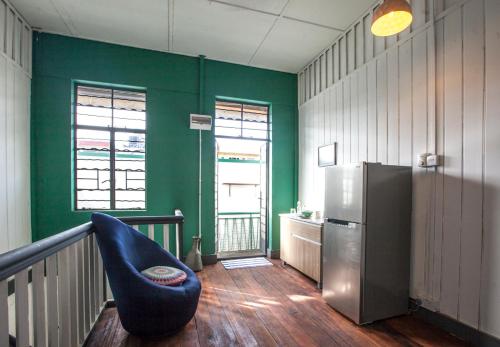 a living room with a refrigerator and a blue couch at The Jungalow in Kota Kinabalu