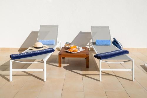 two chairs with blue cushions sitting next to a table at Belado Residence Bol in Bol