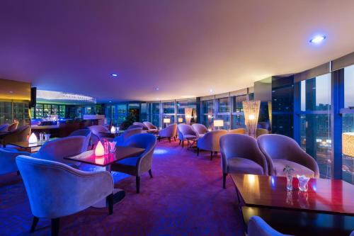 a restaurant with chairs and tables and a large window at Grand Mercure Xiamen Downtown-Free Welcome Fruit & Metro Station in Xiamen