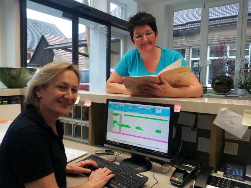 two women sitting at a desk with a computer at Stadler Hof in Großgundertshausen