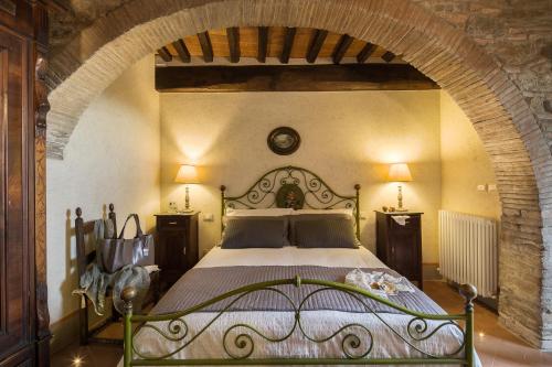 a bedroom with a large bed with an archway at Belvedere in Cortona