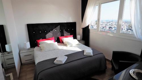 マズノウにあるCristina Port & Beach - Apartmentのベッドルーム1室(赤い枕のベッド2台、窓付)