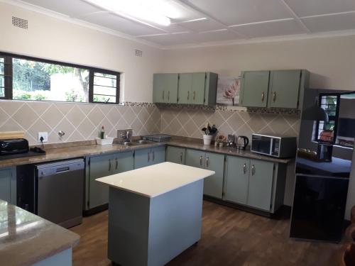a kitchen with green cabinets and a white counter top at De Mist Graskop in Graskop
