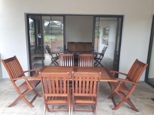 a wooden table with four chairs around it at De Mist Graskop in Graskop