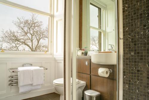 a bathroom with a toilet and a sink and a window at Black Ivy in Edinburgh