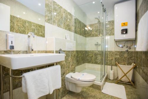 a bathroom with a sink and a toilet and a shower at Villa Four Winds II in Dubrovnik